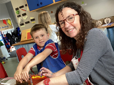 Artist Jane helps a school pupil with a print activity